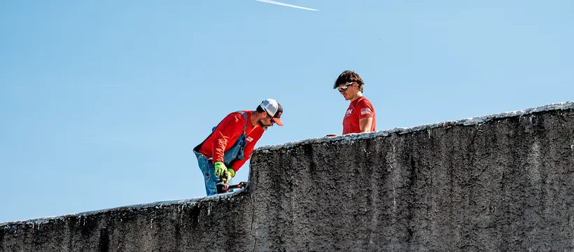 Titan Roofing crew working along the parapet of a commercial building