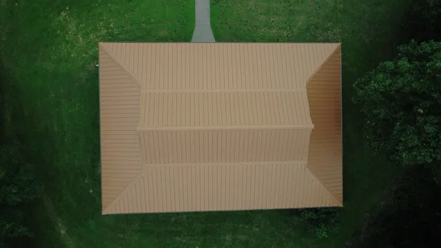 Aerial view of an outbuilding with a new tan standing-seam metal roof