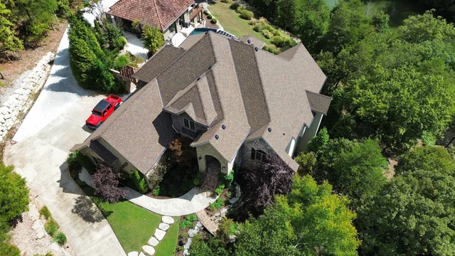 Aerial view of a hillside home with a new brown architectural shingle roof