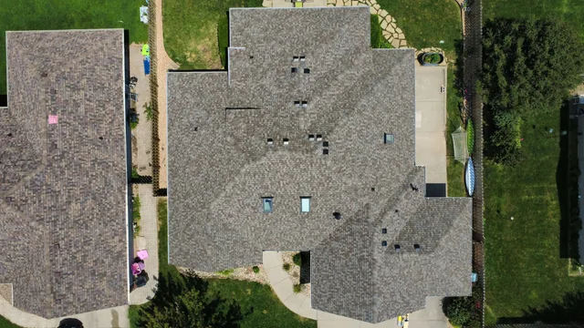 Aerial view of a large home with a new driftwood-toned architectural shingle roof
