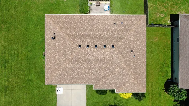 Aerial view of a ranch home with a new tan architectural shingle roof