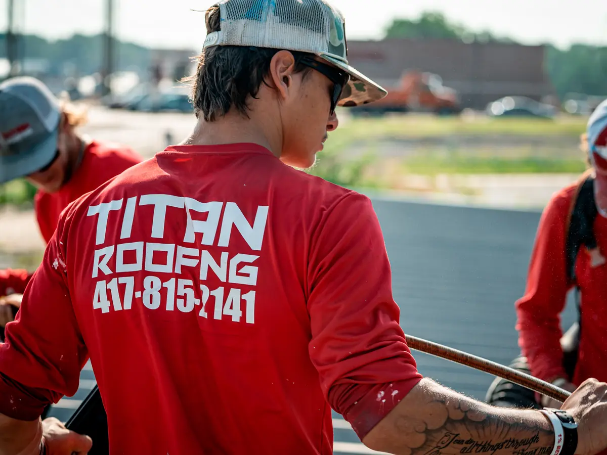 Titan Roofing crew members in red Titan shirts working on a commercial roof