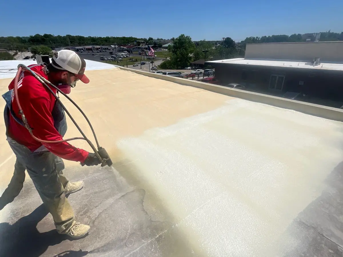 Titan crew member spray-applying foam roofing on a commercial building