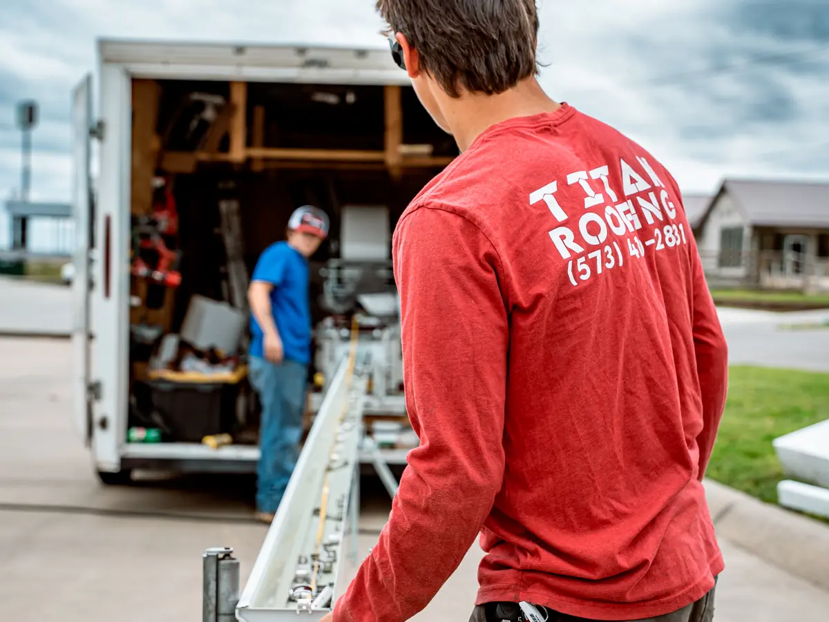 Titan crew member running a seamless gutter machine at the job site