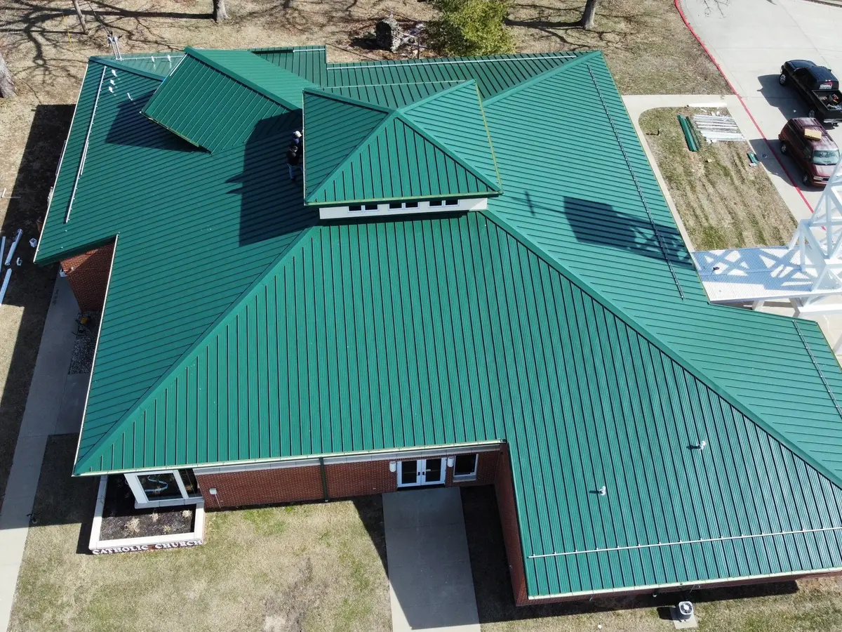 Brick home with a new green metal roof, seen from above
