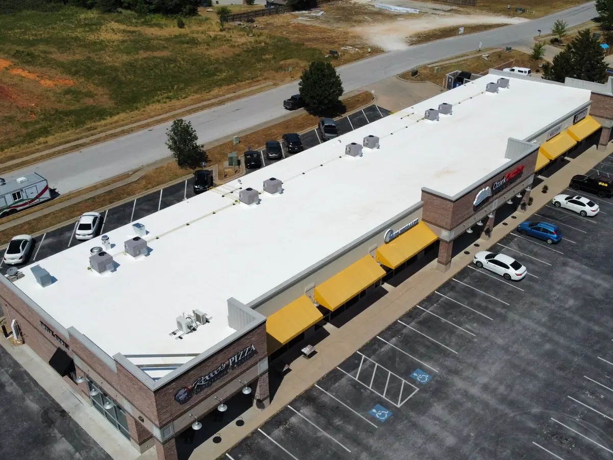 Retail strip center with a white membrane roof, seen from above