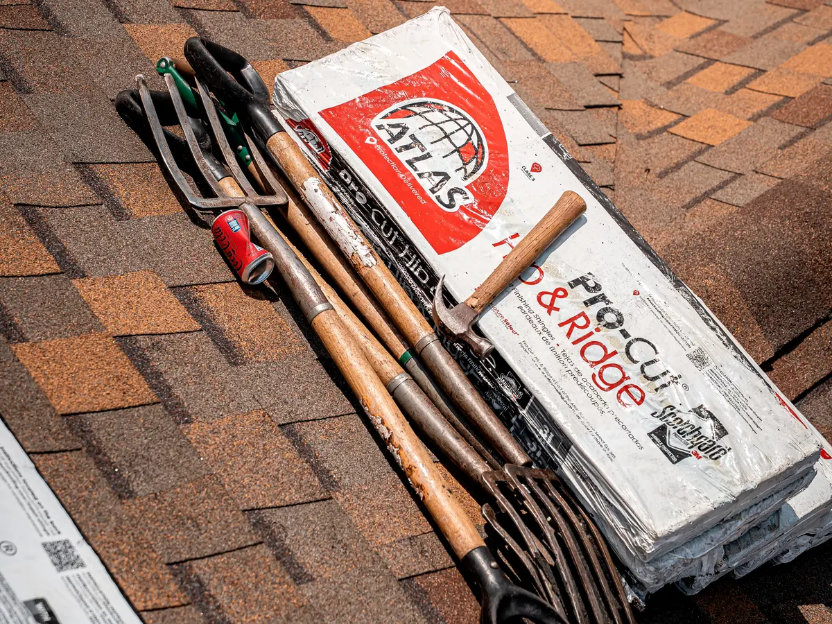 Atlas hip and ridge shingles and roofing tools staged on a new roof