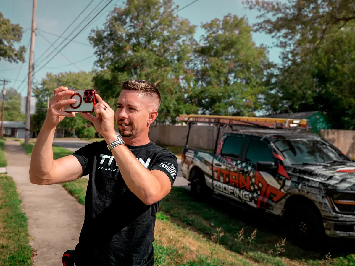 Titan Roofing inspector photographing a home's exterior for a storm damage claim