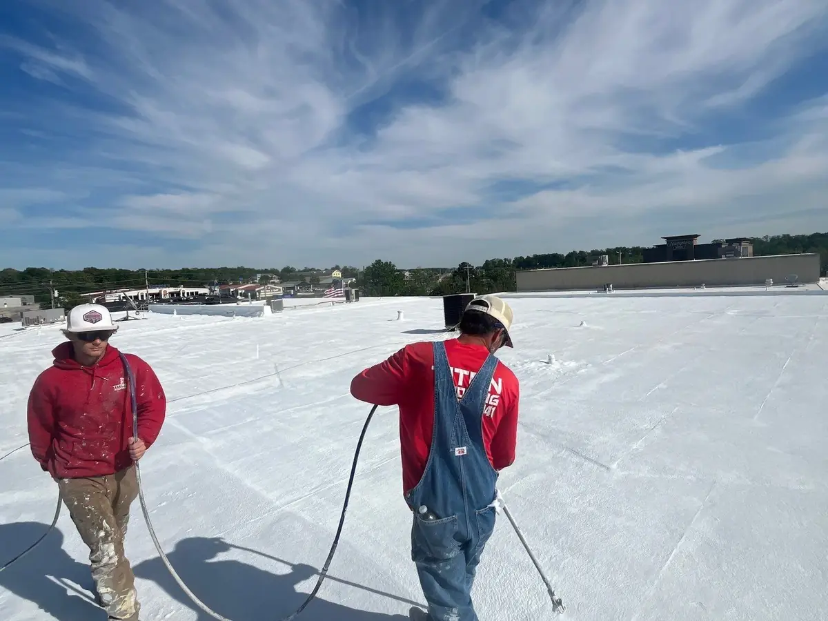 Two Titan crew members working across a spray foam roof