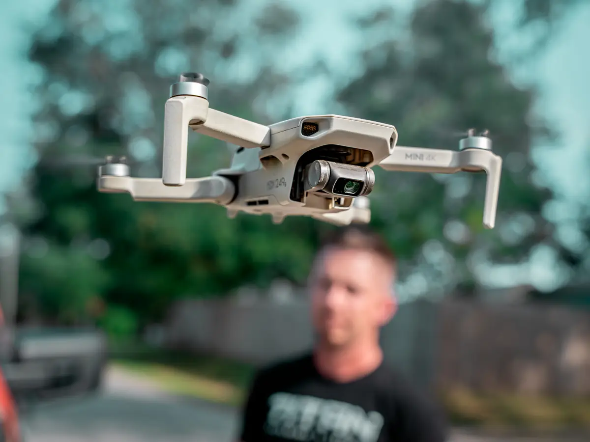 Inspection drone lifting off with a Titan Roofing inspector behind it
