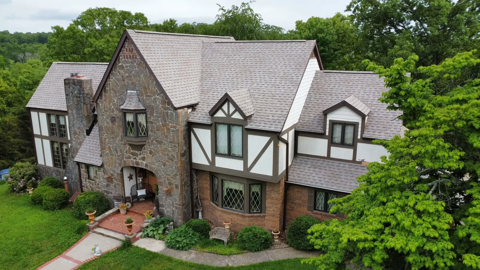 Stone and stucco home with a new architectural shingle roof installed by Titan Roofing