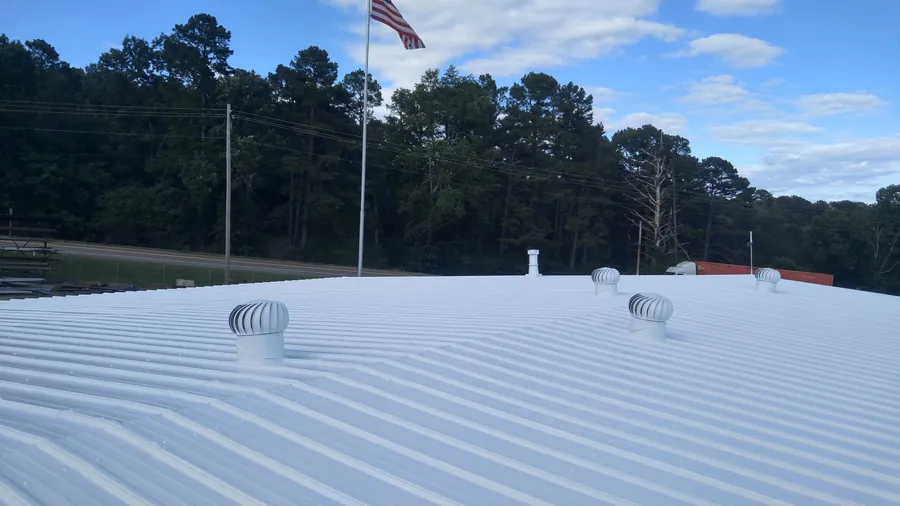 Commercial metal roof with a new white coating and turbine vents