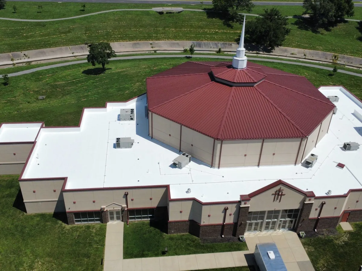 Church with a newly coated white flat roof, seen from above