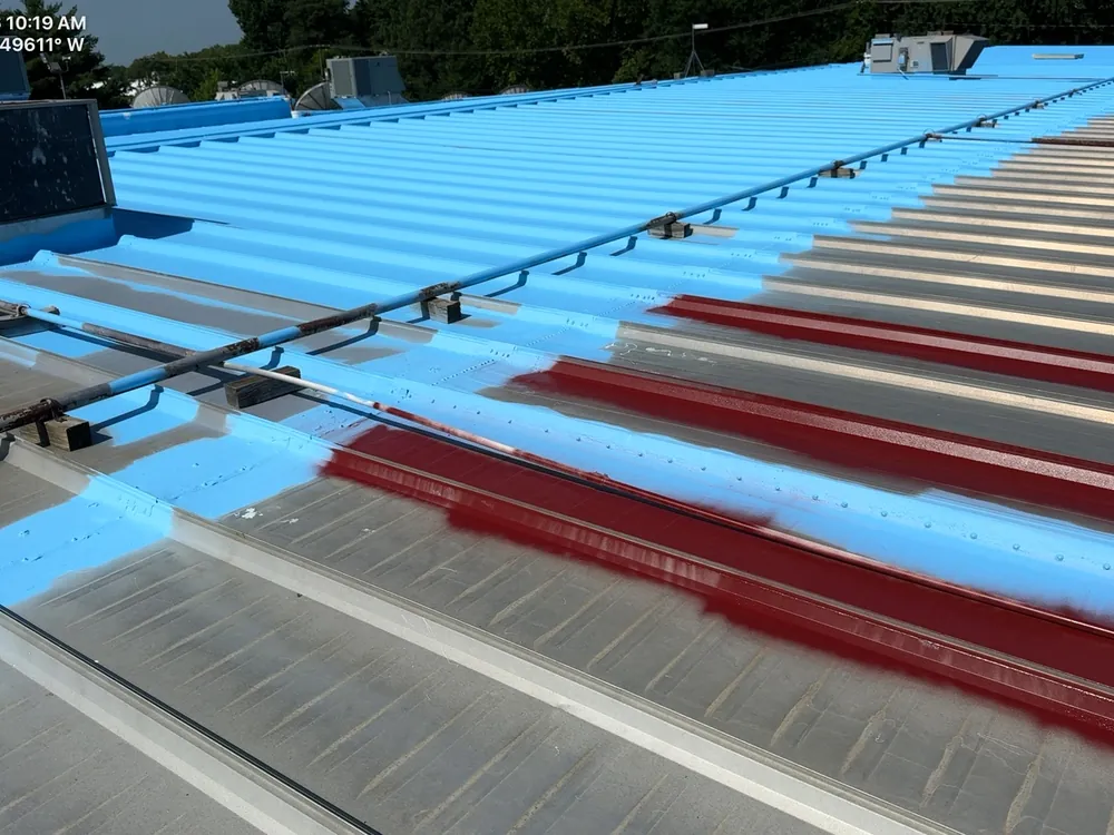 Fresh blue coating rolled over a red ribbed metal roof