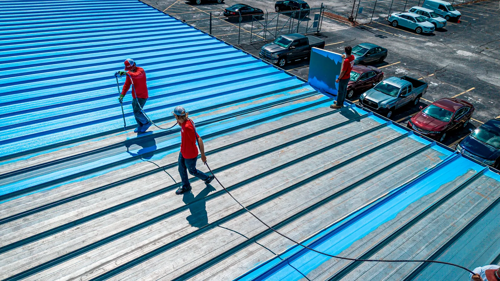 Titan crew rolling a fluid-applied coating onto a standing-seam metal roof