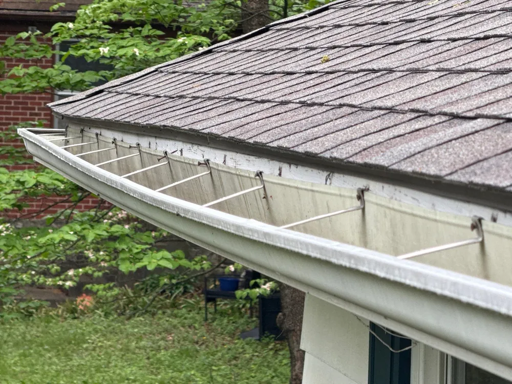 Seamless white gutter along a shingle roof