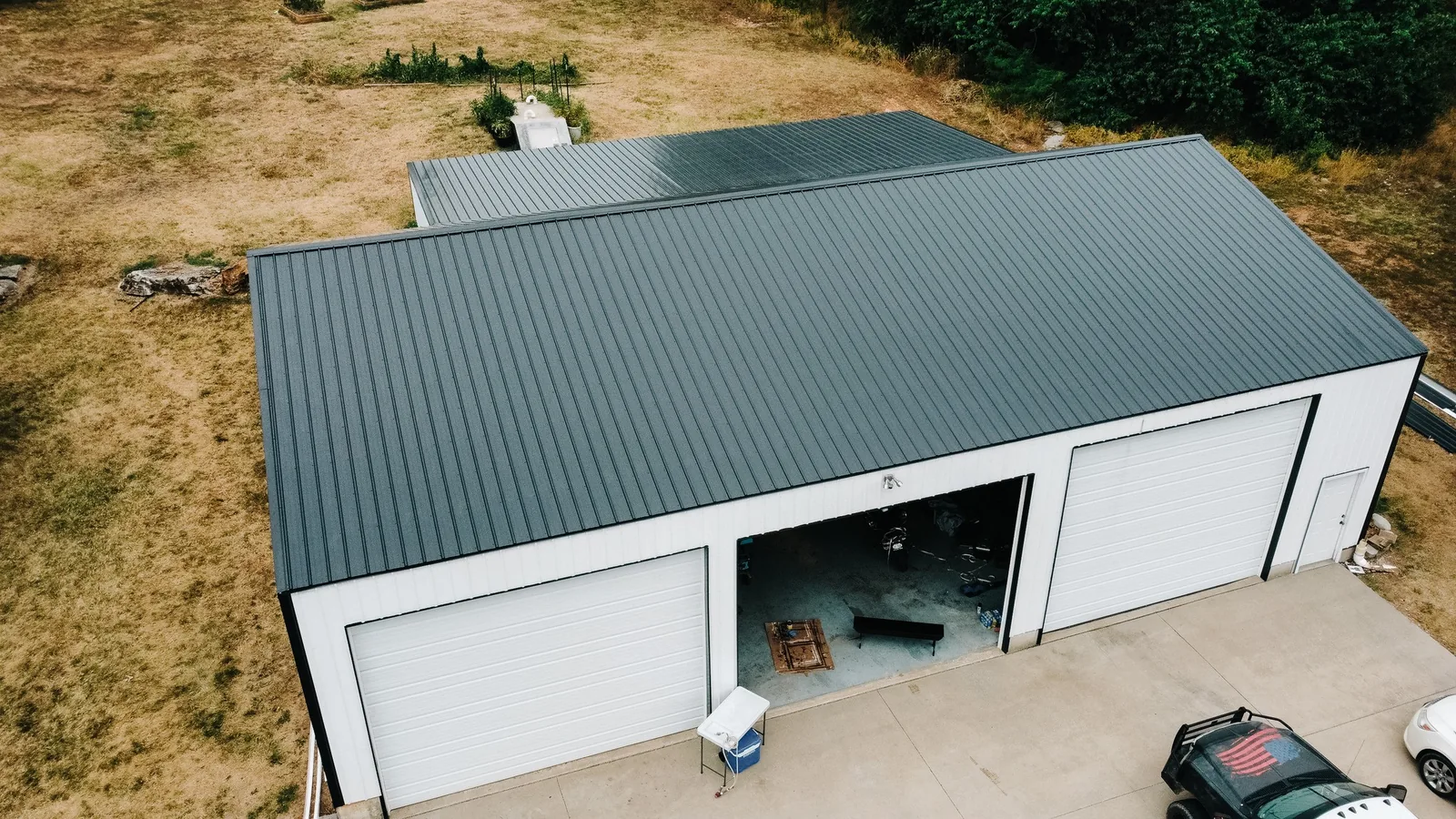 Shop building with a black standing seam metal roof, seen from above