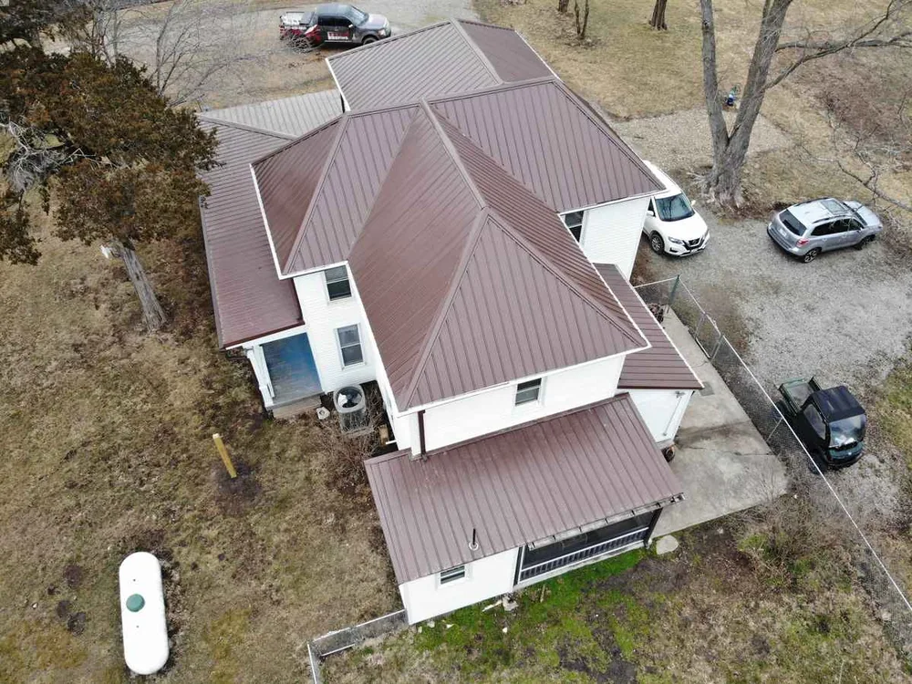 Two-story home with a new brown standing seam metal roof, seen from above