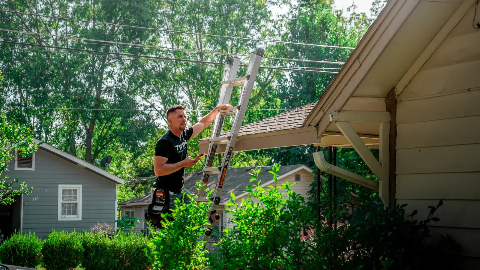 Titan inspector setting a ladder against a home with lap siding before an exterior inspection