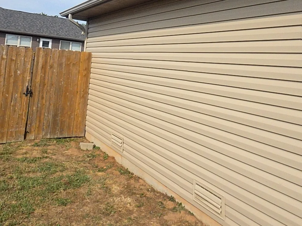 Freshly installed tan vinyl siding on the side of a home