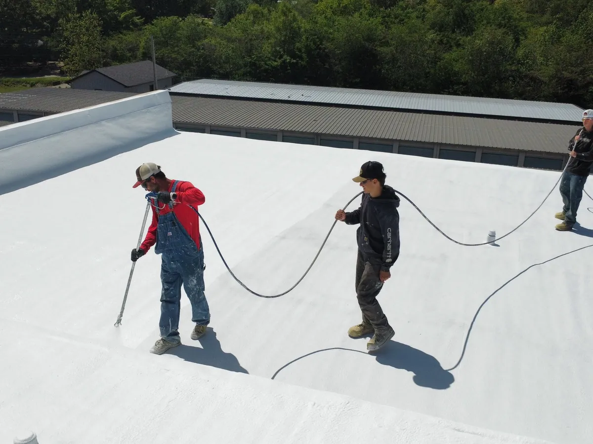 Titan crew coating a spray foam roof, seen from above