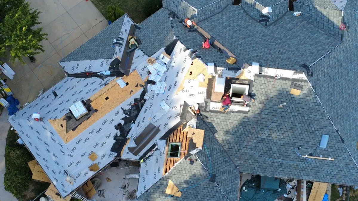The same roof mid-install, with new decking, underlayment and synthetic slate going on