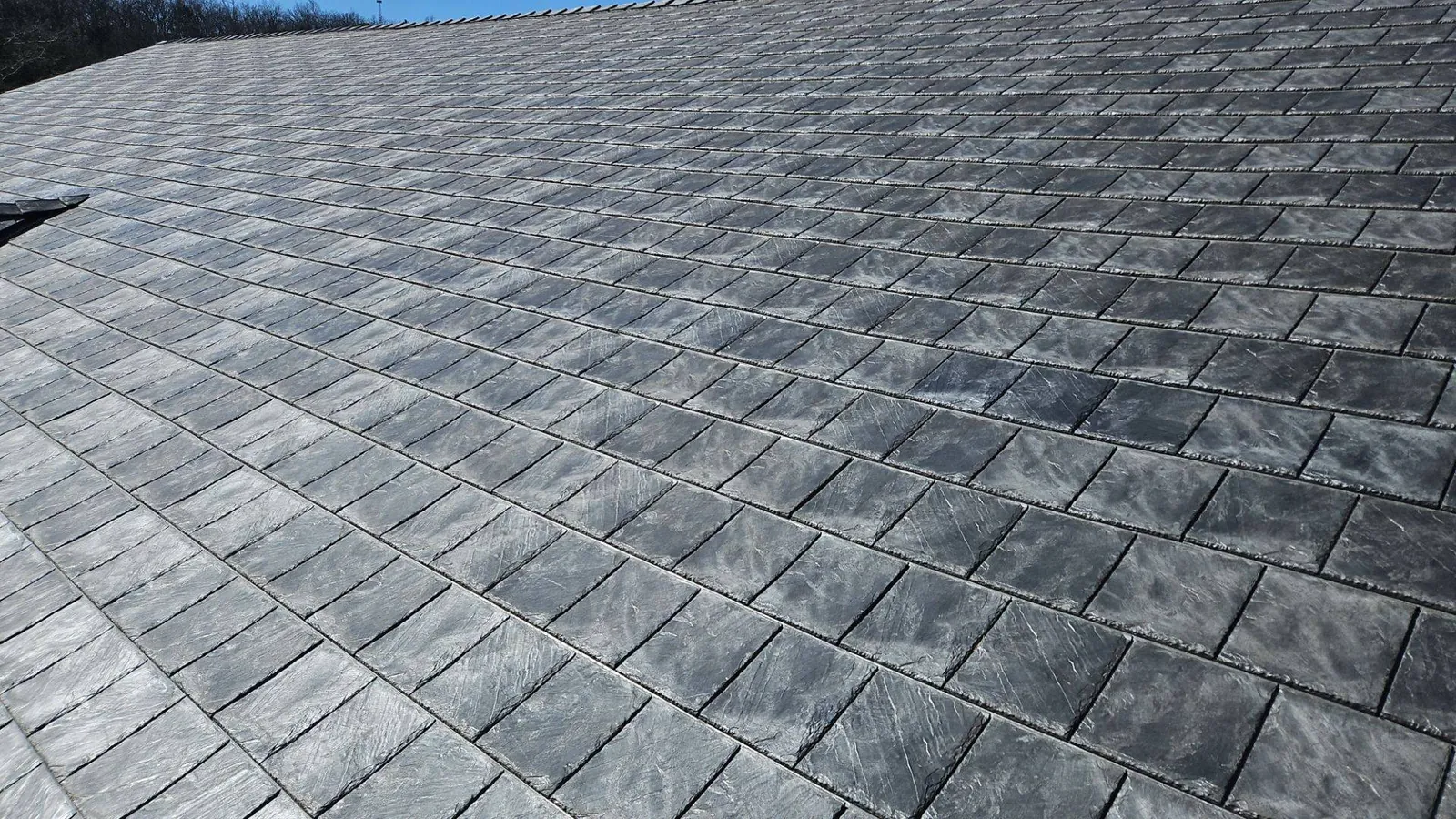 Close-up of synthetic slate tiles with chiseled edges and natural stone texture on a Titan Roofing job