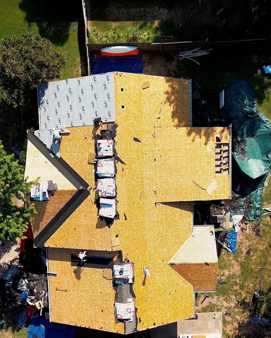 A home mid roof replacement, old shingles torn off down to new decking, seen from above