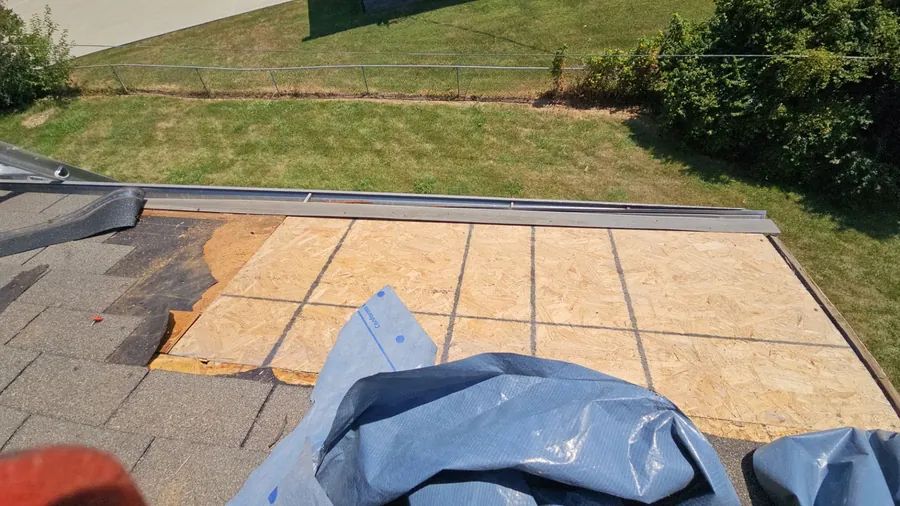 Roof deck exposed during a repair, tarp and new decking in place